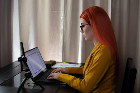 Tired woman working at home very late with her computer and cell phone