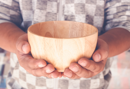 vintage of hungry man holding an empty wooden bowlの写真素材
