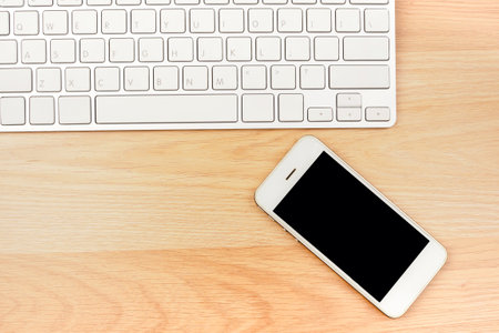 Business working smart phone laptop on brown wooden table background. top view