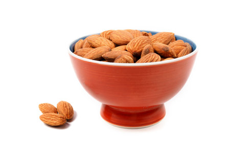 almond seeds in brown bowl on white background.  top viewの写真素材