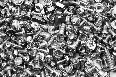 Gray texture background of many randomly scattered computer screws