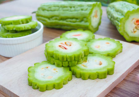 Fresh bitter gourd in white bowl on wooden tableの写真素材