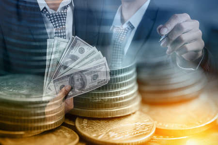Businessman with money in hand, US dollar, Rows of coins for finance and Saving conceptの写真素材