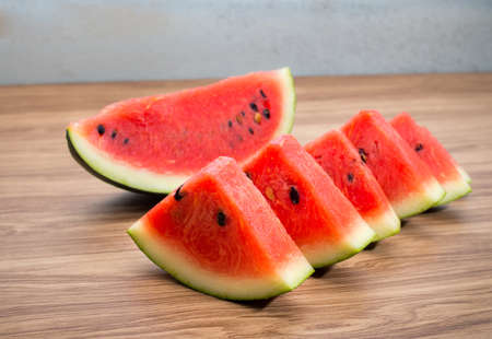 Fresh sliced watermelon on brown wooden table backgroundの写真素材