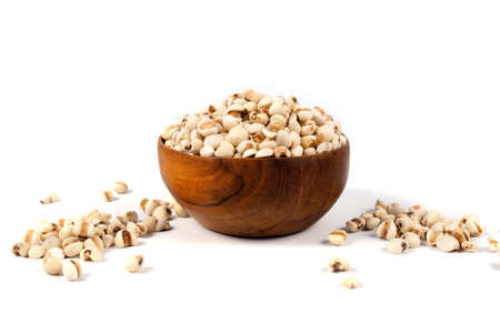 Organic millet grains on wood bowl on white background.の写真素材