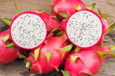 Ripe red dragon fruit on old wooden table backgroundの写真素材