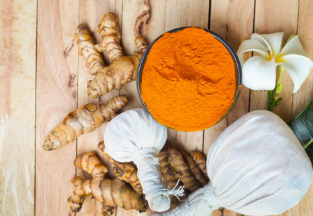 Turmeric powder and fresh in bowls on wooden table. herbalの写真素材