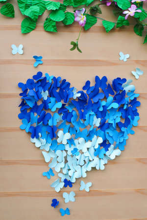 Butterfly made of paper with heart on wood wall backgroundの写真素材
