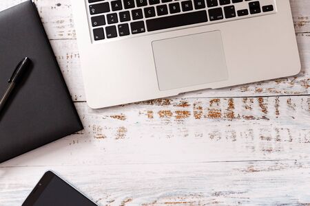 Flat lay on wooden background with black vintage camera and laptop, ideal for marketing