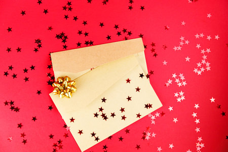 Christmas letter on red background with holiday items and glittered stars.の写真素材