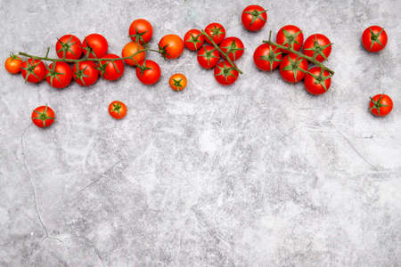 Natural product concept. Fresh cherry tomatoes on gray background.
