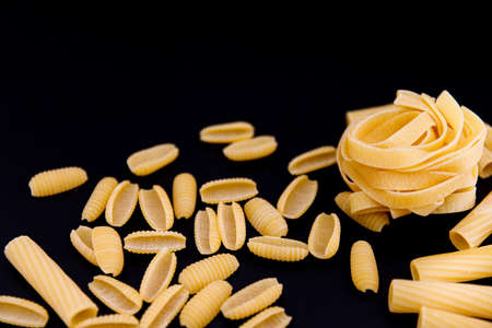 Italian pasta closeup on black background. Macaroni. Spaghetti. Selective Focus.