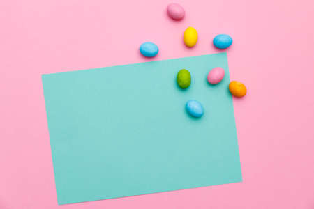 Easter bunny. Happy Easter holiday background concept.Flat lay colorful bunny egg with accessory to celebration on modern rustic pink pastel paper at home office desk.の写真素材