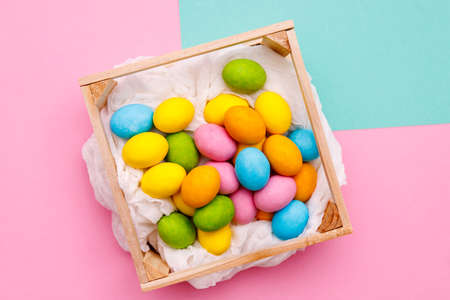 Easter bunny. Happy Easter holiday background concept.Flat lay colorful bunny egg with accessory to celebration on modern rustic pink pastel paper at home office desk.の写真素材