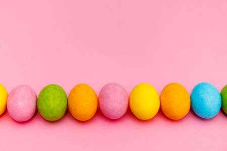Easter bunny. Happy Easter holiday background concept.Flat lay colorful bunny egg with accessory to celebration on modern rustic pink pastel paper at home office desk.の写真素材