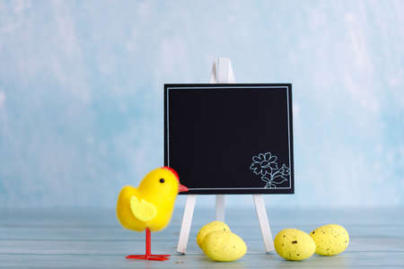 The minimal concept of Easter. An Easter card with a copy of the place for the text. Chicken and wooden board for text.の写真素材