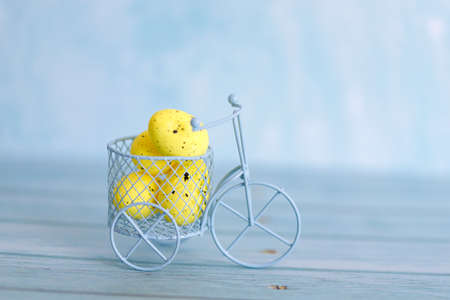 White toy bicycle with yellow Easter eggs. Easter greeting card with abstract scene with eggs in yellow colors. Delivery on Easter.の写真素材
