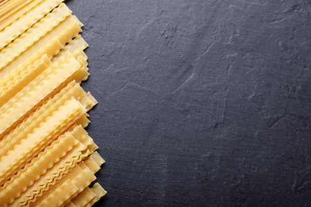 Raw uncooked pasta on a black backgroundの写真素材