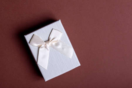 Craft gift box on a black background, decorated with a bow. For birthday, anniversary presents, gift post cards.の写真素材