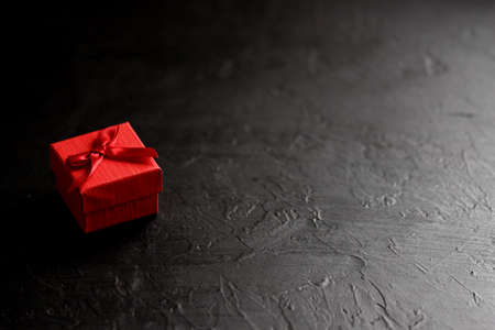 Craft gift box on a black background, decorated with a bow. For birthday, anniversary presents, gift post cards.の写真素材