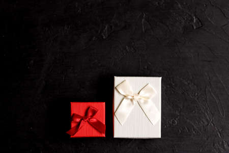 Craft gift box on a black background, decorated with a bow. For birthday, anniversary presents, gift...