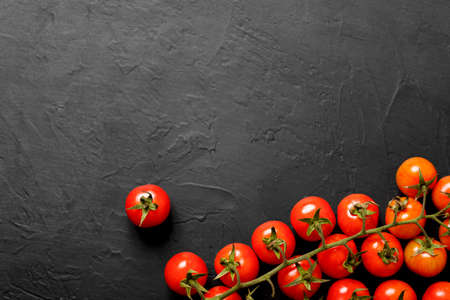Cherry tomatoes on a black background, top view.の写真素材