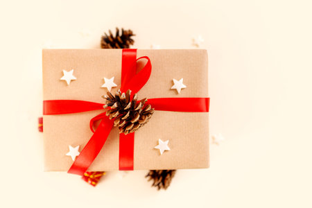 Christmas gift box with red bow on beige background. Holiday concept, New year presents.の写真素材