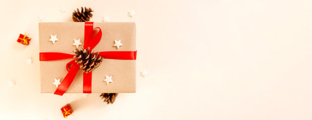 Christmas gift box with red bow on beige background. Holiday concept, New year presents.