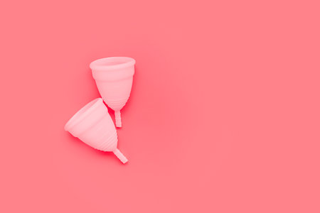Pink menstrual cup on color background, female intimate hygiene period products, top viewの写真素材