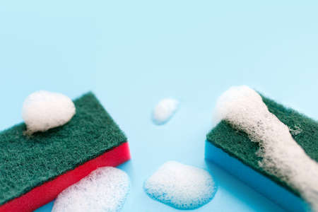 Multicolored sponges for cleaning on a blue background. Space for textの写真素材
