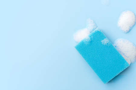 Multicolored sponges for cleaning on a blue background. Space for textの写真素材