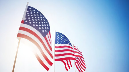 Multiple American Flags Waving Against Clear Blue Sky on Patriotic National Holiday Celebration