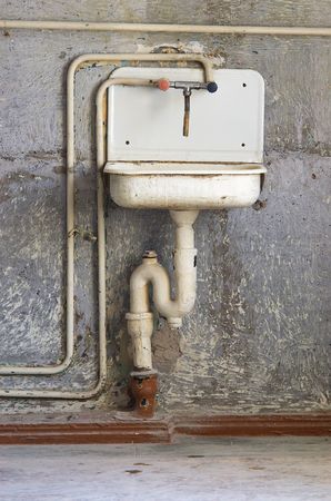 aging dirty, blanching kitchen washer on background old victimized wallの写真素材