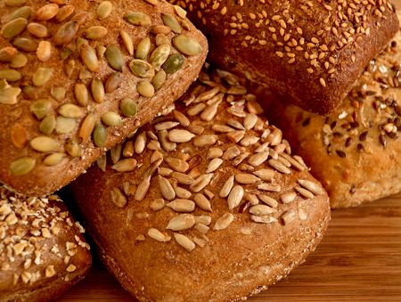 Assortment of multi-grain bread rolls on wooden table
