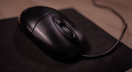 small black mouse on the black mat.の写真素材