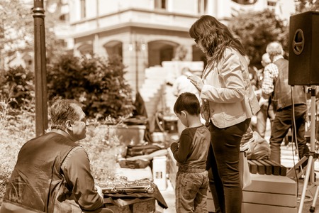DIMITROVGRAD, BULGARIA - APRIL 30, 2018: Saxophone player shows his sax to young boy and his mother...