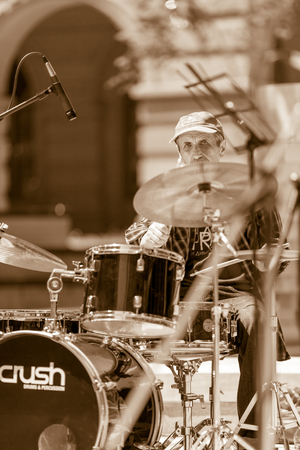 DIMITROVGRAD, BULGARIA - APRIL 30, 2018: Male drummer plays music in the open while looking in the camera at street concert event dedicated to International World Jazz Dayのeditorial素材