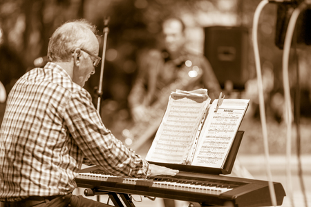 DIMITROVGRAD, BULGARIA - APRIL 30, 2018: Jazz notes of the pianinst stand put over his piano while the musician is playing at street concert event dedicated to International World Jazz Dayのeditorial素材