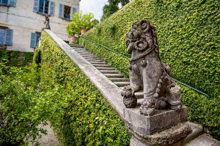 Beautiful green bushes old stone staircase with lion statue decoration at Isola Bella island in lake Lago di Maggiore. Italy, springtime.の写真素材