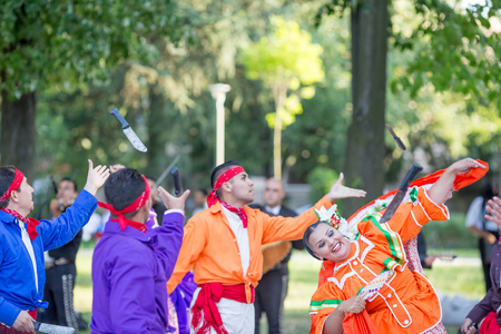 KAZANLAK, BULGARIA - JULY 21, 2016: Beautiful Mexican dancers in traditional costumes from Mexico amazingly perform a spectacular fast dance at a free open festival in the city park at summerのeditorial素材