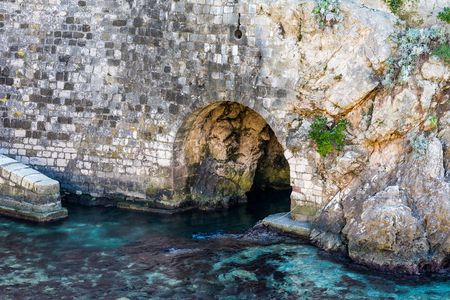 Ancient tunnel at the old castle of Dubrovnik, Croatia passing under the city walls directly into the crystal blue waters of Adriatic Seaのeditorial素材