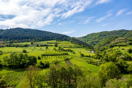 Serbian rural village green springtime landscape, mountains in Serbia are very beautiful, near Valjevo. Valley and hills. White house, farmland and spring forest in spring. European countrysideの写真素材