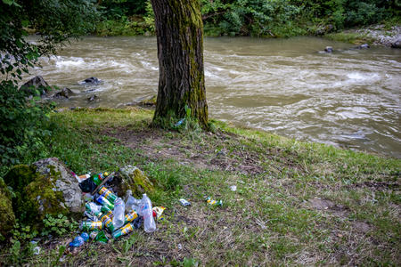 DEBNEVO, BULGARIA - JULY 26, 2018: Pile of plastic and metallic garbage, mostly beer cans and water bottles being left to pollute the riverbed after camping near the Vidima river in Northern Bulgariaのeditorial素材