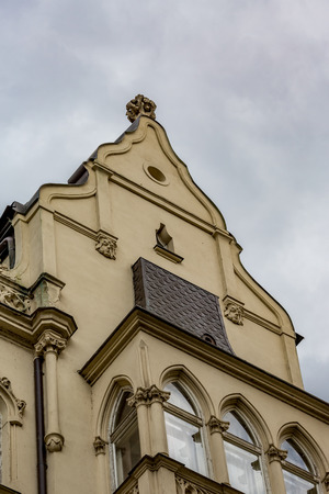 Impressive old architecture building facade in Prague in a warm summer day with puffy white clouds. Oriental style windows and faces as ornamentsの写真素材