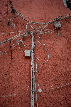 Telecommunication wiring, a chaotic pile of cables, boxes and connection painted in white on newly...