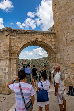 MATERA, ITALY - AUGUST 27, 2018: Several tourists wait for free spot to take selfie at balcony with arch near Church of St.Peter also known as Chiesa di San Pietro Caveoso, warm summer overcast dayのeditorial素材