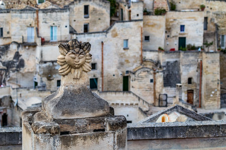 Summer day high-angle scenery street view of an artistic chimney decoration over the amazing ancient town of the Sassi with blurred background of pattern of buildings in Matera, Basilicata, Italyの写真素材