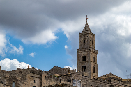 Summer blue sky and church roof with religious cross, view of ancient town of Matera, the Sassi di Matera, Basilicata, Southern Italy, cloudy summer August dayの写真素材