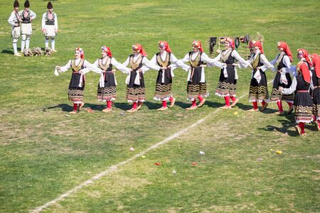 VARVARA, BULGARIA - MARCH 24, 2019: Moment from National Festival Dervish Varvara presents traditions of Bulgarian Kuker Games. Female round dance performed on local stadiumのeditorial素材