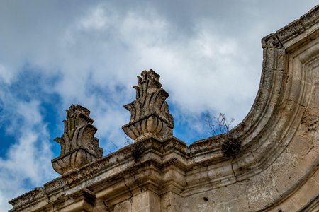 Rooftop decorations, architectural detail from the historic center of Matera, Italy, Basilcata region, low point of view from below, scenery summer day with puffy white cloudsの写真素材